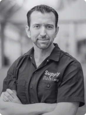 Professional headshot of confident man in work uniform with embroidered logo